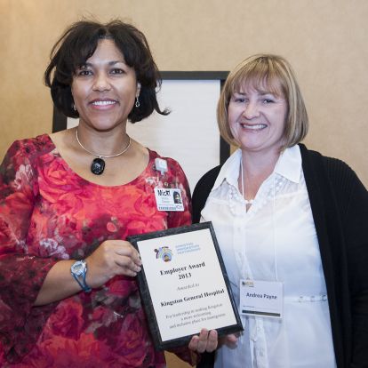 Micki Muima, Director of Healthy Workplace Services (left) accepts the Employer Award 2013 from Andrea Payne of the Kingston Immigration Partnership at the Residence Inn Mariott.